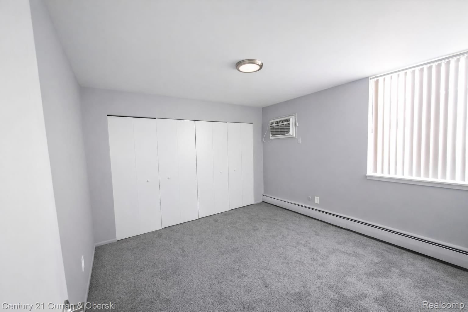 6035 Southfield Road, Unit 12 Detroit, MI 48228 - Photo 9 of 10 Unfurnished bedroom with baseboard heating, carpet floors, and a closet