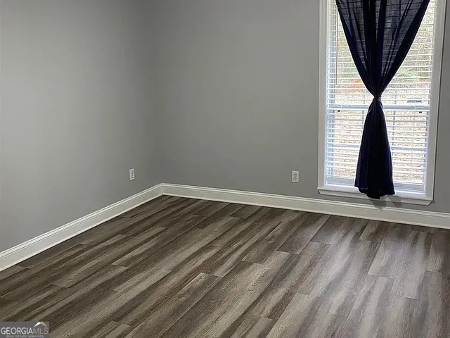 a view of a kitchen with wooden floor and electronic appliances