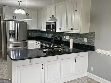 a kitchen with stainless steel appliances granite countertop a sink a stove and a refrigerator