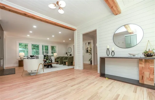 a living room with furniture a mirror and a large window