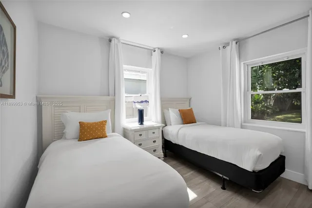 a view of a livingroom with furniture a kitchen and wooden floor