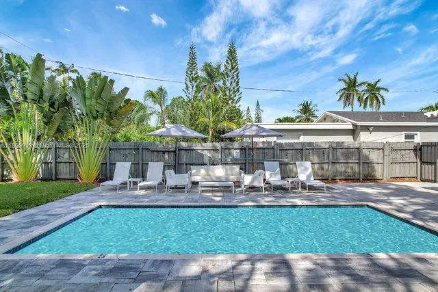 a view of a house with backyard and sitting area