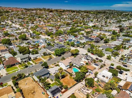 an aerial view of a residential houses with street and trees
