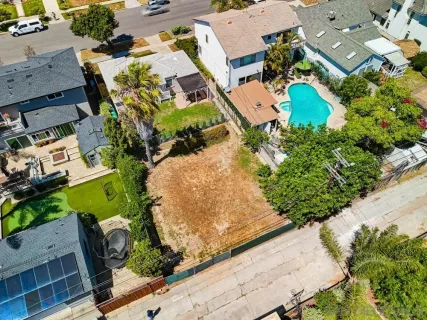 an aerial view of a house with a yard and a wooden deck