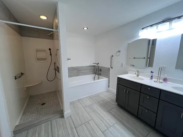 a bathroom with a shower sink and mirror