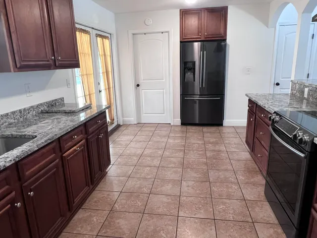 a kitchen with stainless steel appliances granite countertop a refrigerator and a sink