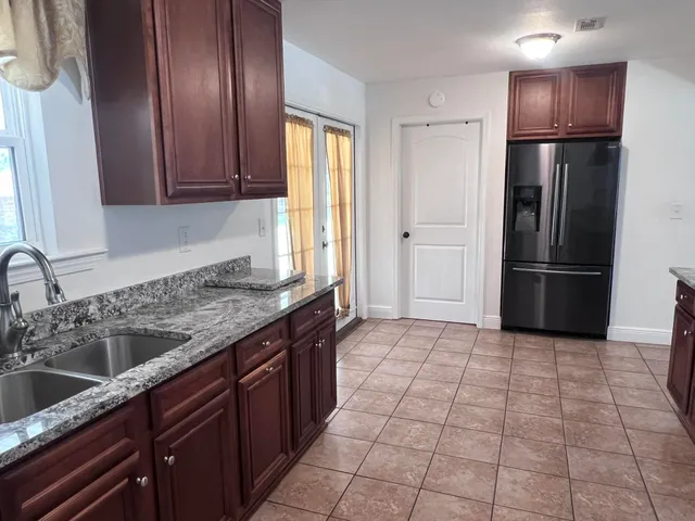a kitchen with a refrigerator sink and cabinets
