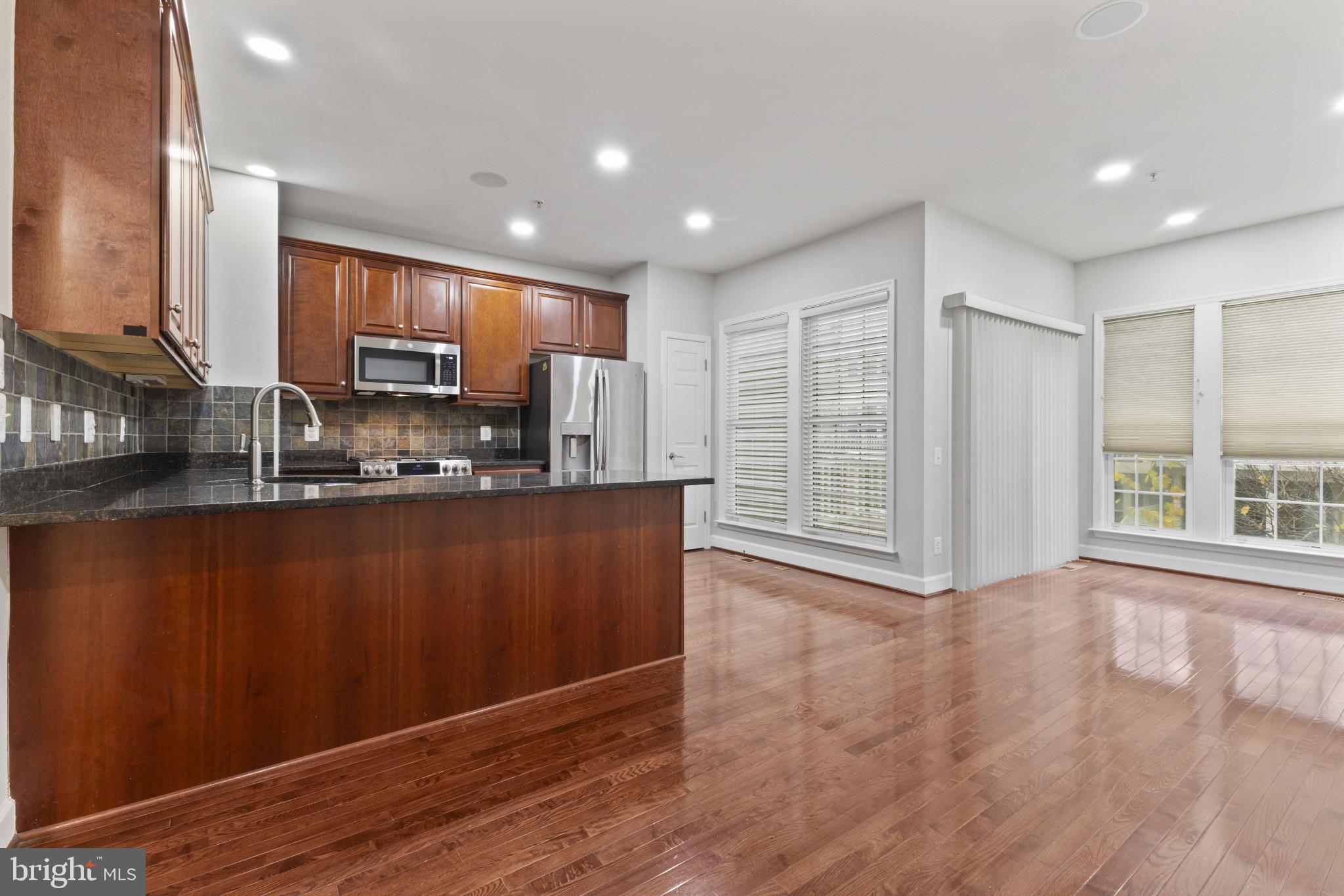 573 Dandelion Terrace Southeast Leesburg, VA 20175 - Photo 8 of 31 a view of kitchen with stainless steel appliances granite countertop a refrigerator a stove a sink and a large window