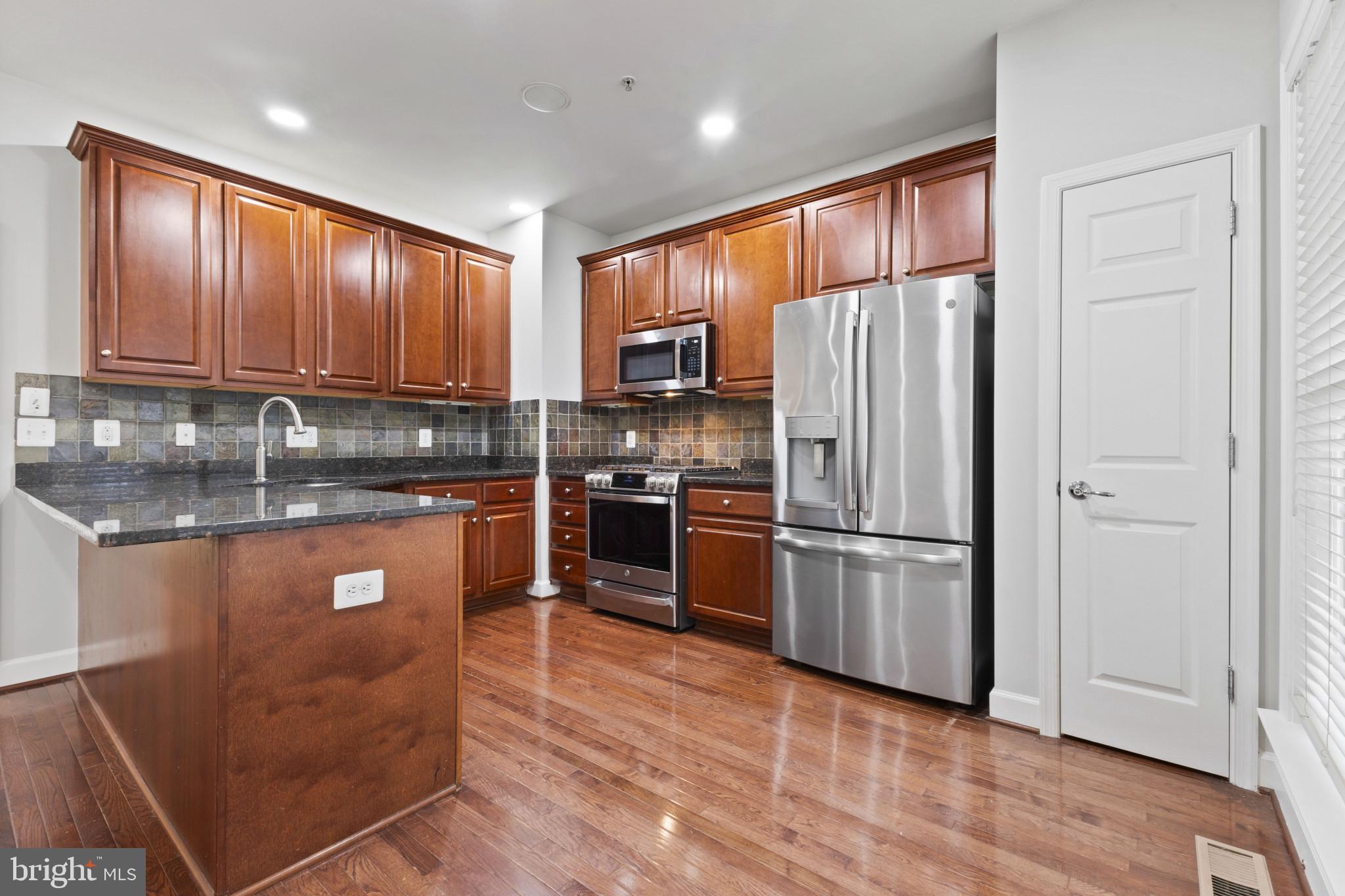 573 Dandelion Terrace Southeast Leesburg, VA 20175 - Photo 9 of 31 a kitchen with granite countertop stainless steel appliances a refrigerator a sink a stove a microwave and cabinets