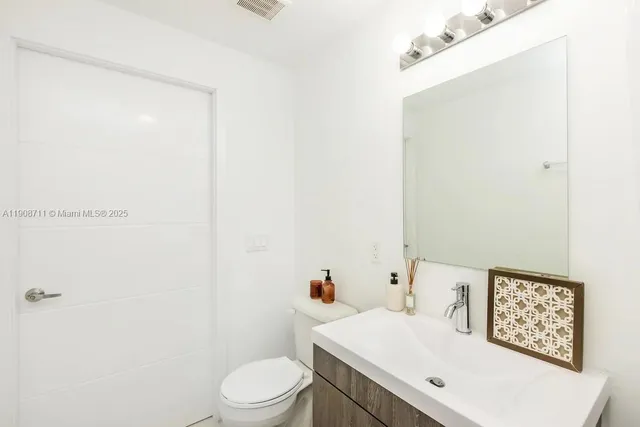 a white toilet sitting next to a bathroom sink