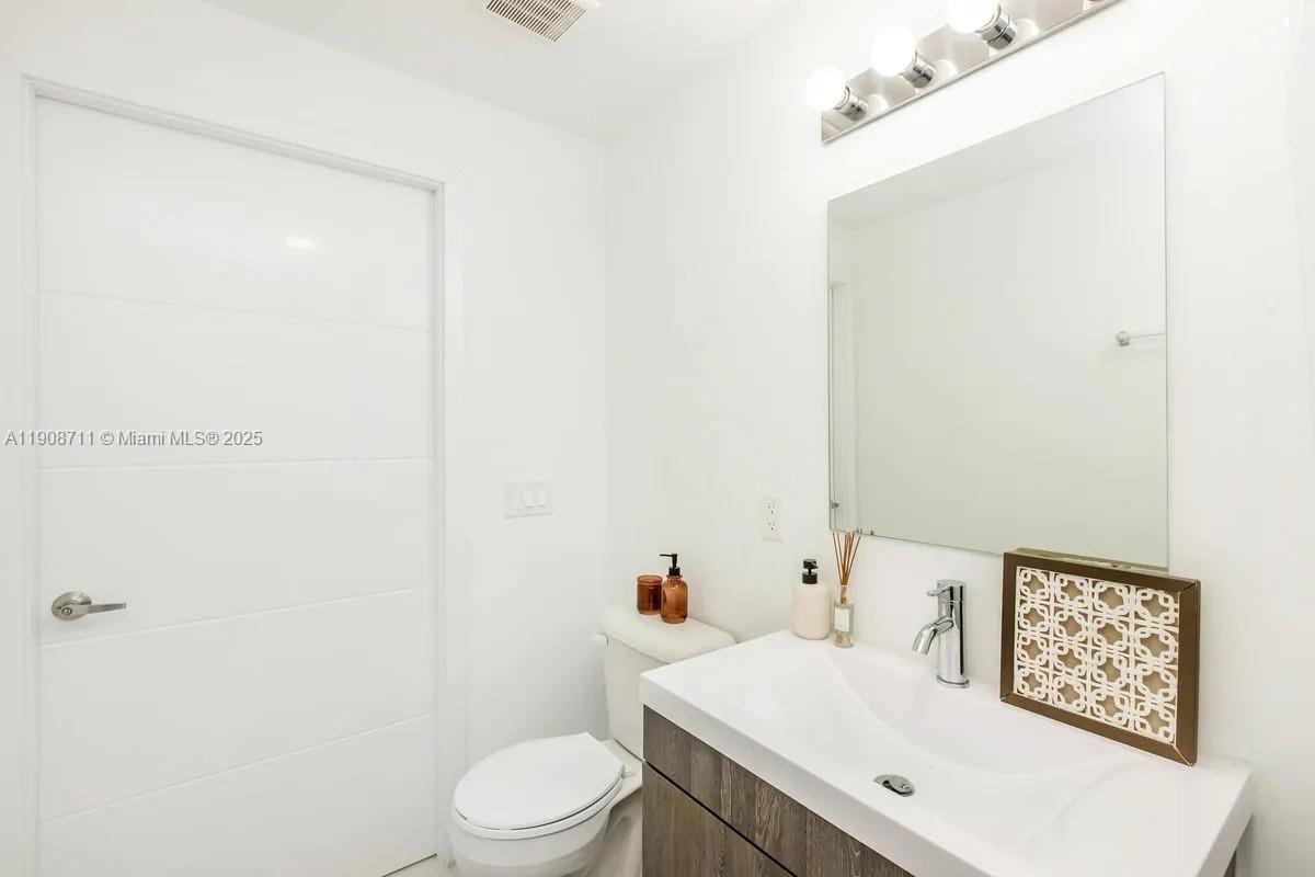 25850 Southwest 140th Court, Unit 6209 Homestead, FL 33032 - Photo 13 of 29 a white toilet sitting next to a bathroom sink