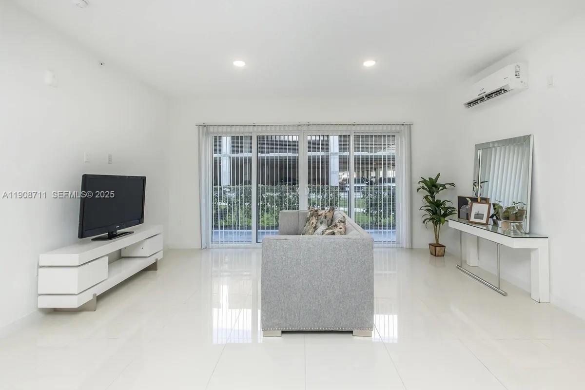 25850 Southwest 140th Court, Unit 6209 Homestead, FL 33032 - Photo 2 of 29 a living room with furniture and a flat screen tv