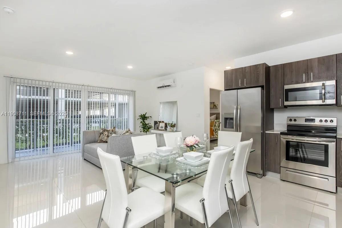 25850 Southwest 140th Court, Unit 6209 Homestead, FL 33032 - Photo 4 of 29 a dining room with furniture a large window and kitchen view