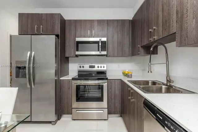 a kitchen with a sink a refrigerator and cabinets