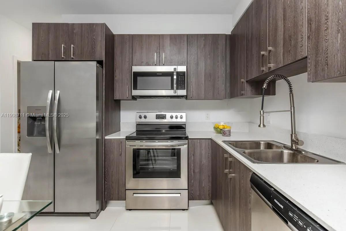 25850 Southwest 140th Court, Unit 6209 Homestead, FL 33032 - Photo 5 of 29 a kitchen with a sink a refrigerator and cabinets