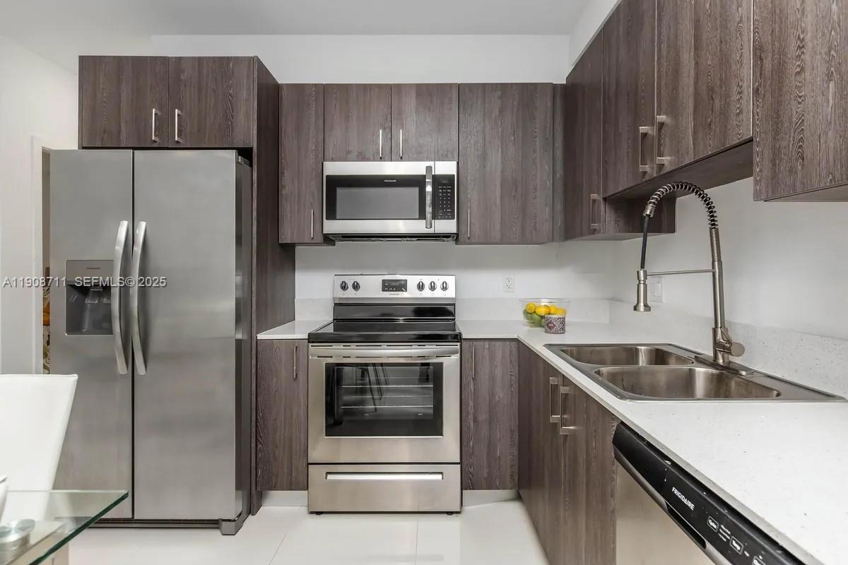 25850 Southwest 140th Court, Unit 6209 Homestead, FL 33032 - Photo 5 of 29 a kitchen with a sink and steel stainless steel appliances