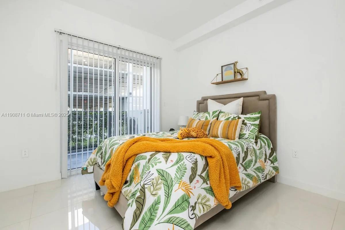 25850 Southwest 140th Court, Unit 6209 Homestead, FL 33032 - Photo 7 of 29 a bed sitting in a bedroom next to a window