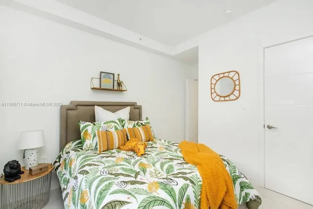 a bedroom with a bed and painting on the wall