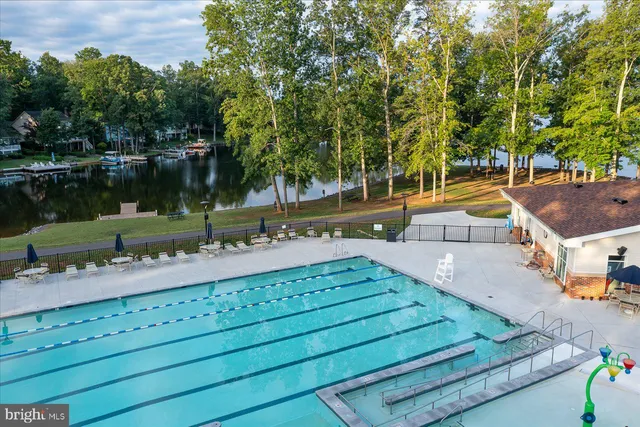 a view of swimming pool with a yard and trees in the background