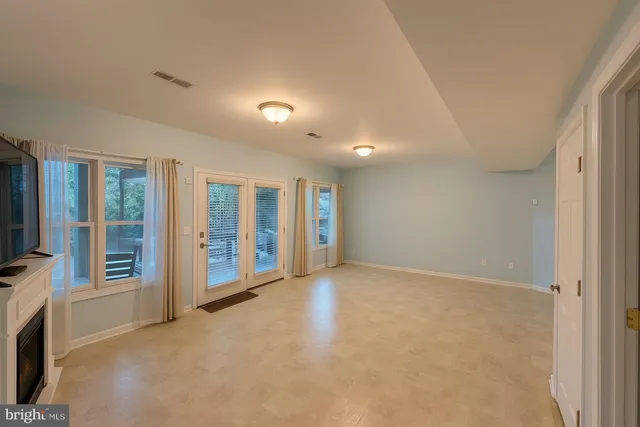 a view of an empty room with a fireplace and a window