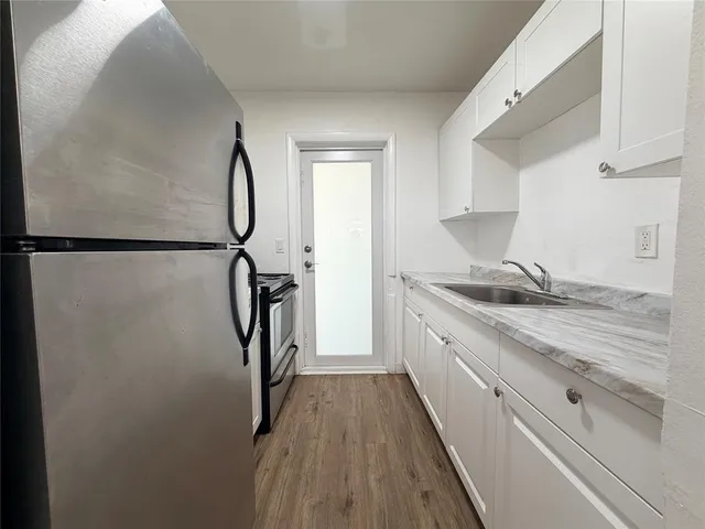a view of a kitchen from a corridor