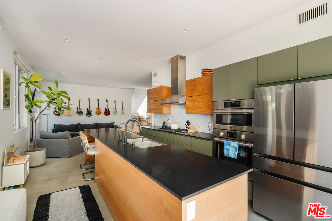 2437 Walnut Avenue Venice, CA 90291 - Photo 15 of 44 a kitchen with stainless steel appliances granite countertop a sink a stove and a refrigerator