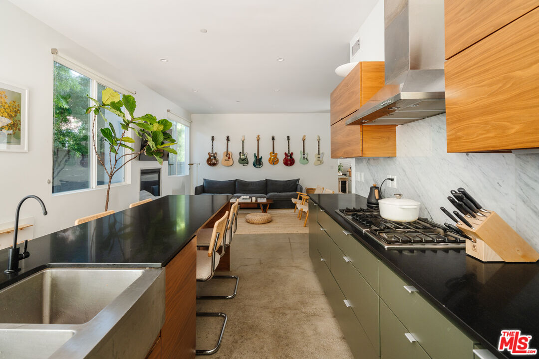 2437 Walnut Avenue Venice, CA 90291 - Photo 16 of 44 a kitchen with stainless steel appliances granite countertop a sink a stove and a wooden cabinets