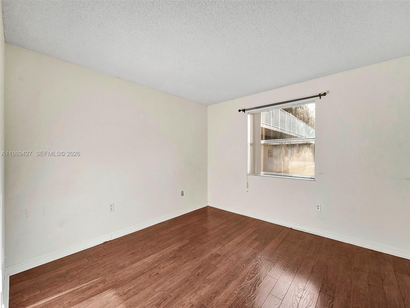 4600 Southwest 67th Avenue, Unit 155 Miami, FL 33155 - Photo 11 of 32 a view of an empty room with wooden floor and a window