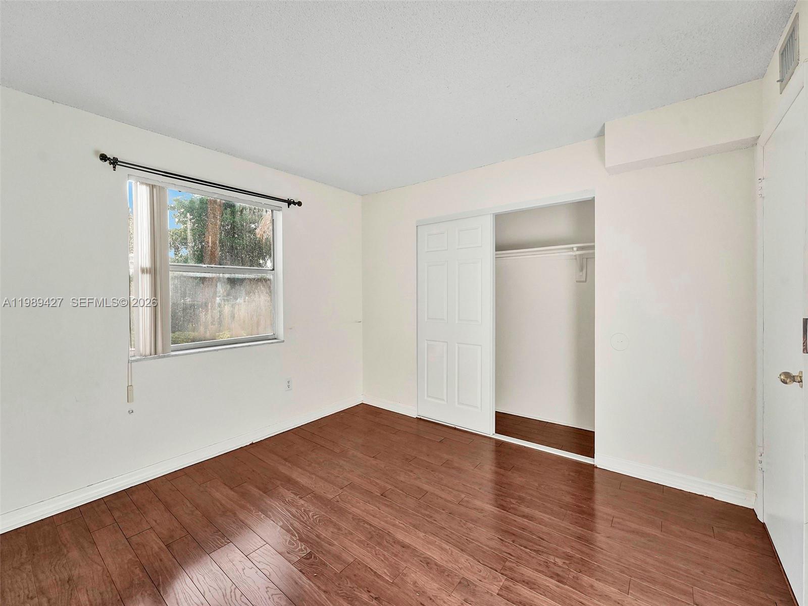 4600 Southwest 67th Avenue, Unit 155 Miami, FL 33155 - Photo 12 of 32 a view of an empty room with wooden floor and a window