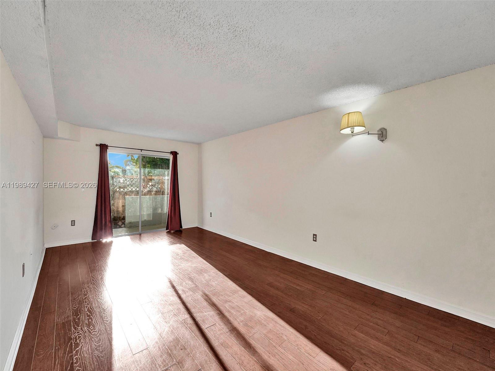 4600 Southwest 67th Avenue, Unit 155 Miami, FL 33155 - Photo 2 of 32 a view of an empty room with wooden floor and windows