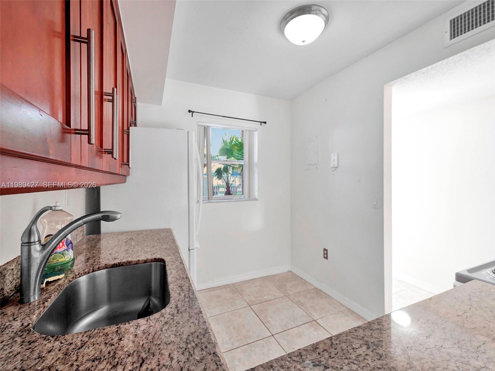 4600 Southwest 67th Avenue, Unit 155 Miami, FL 33155 - Photo 25 of 32 a kitchen with a sink a stove and cabinets