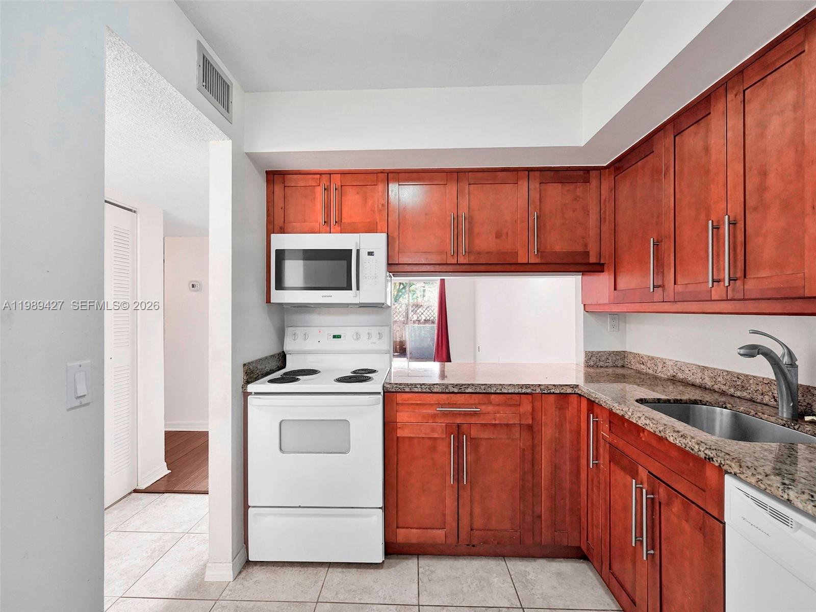 4600 Southwest 67th Avenue, Unit 155 Miami, FL 33155 - Photo 3 of 32 a kitchen with a stove sink and cabinets