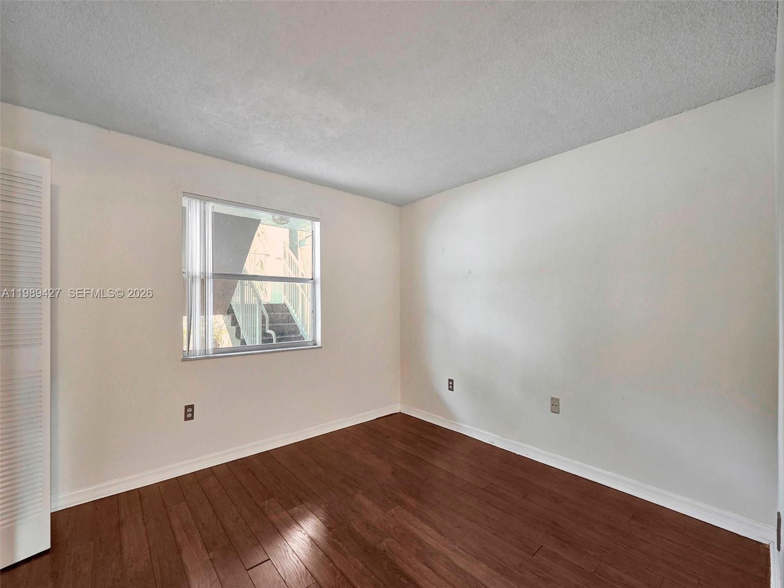 4600 Southwest 67th Avenue, Unit 155 Miami, FL 33155 - Photo 4 of 32 an empty room with wooden floor and windows