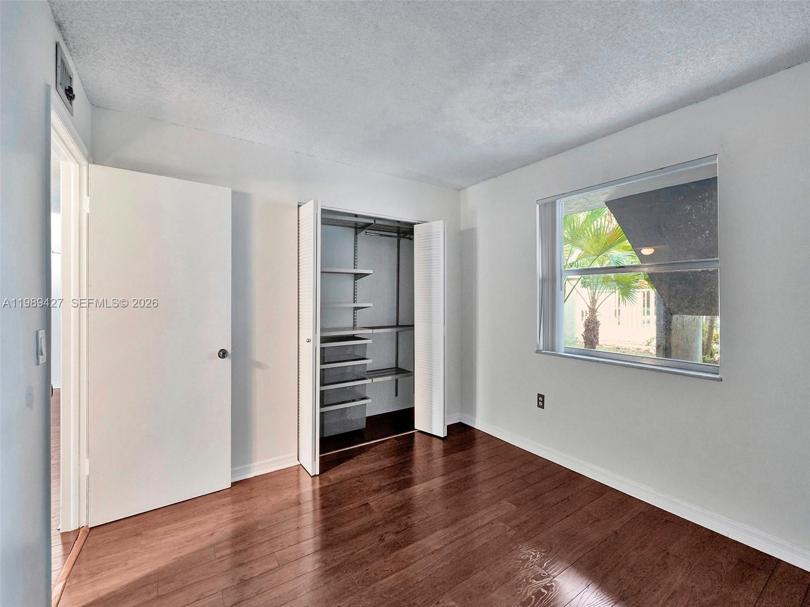 4600 Southwest 67th Avenue, Unit 155 Miami, FL 33155 - Photo 5 of 32 an empty room with wooden floor closet and windows