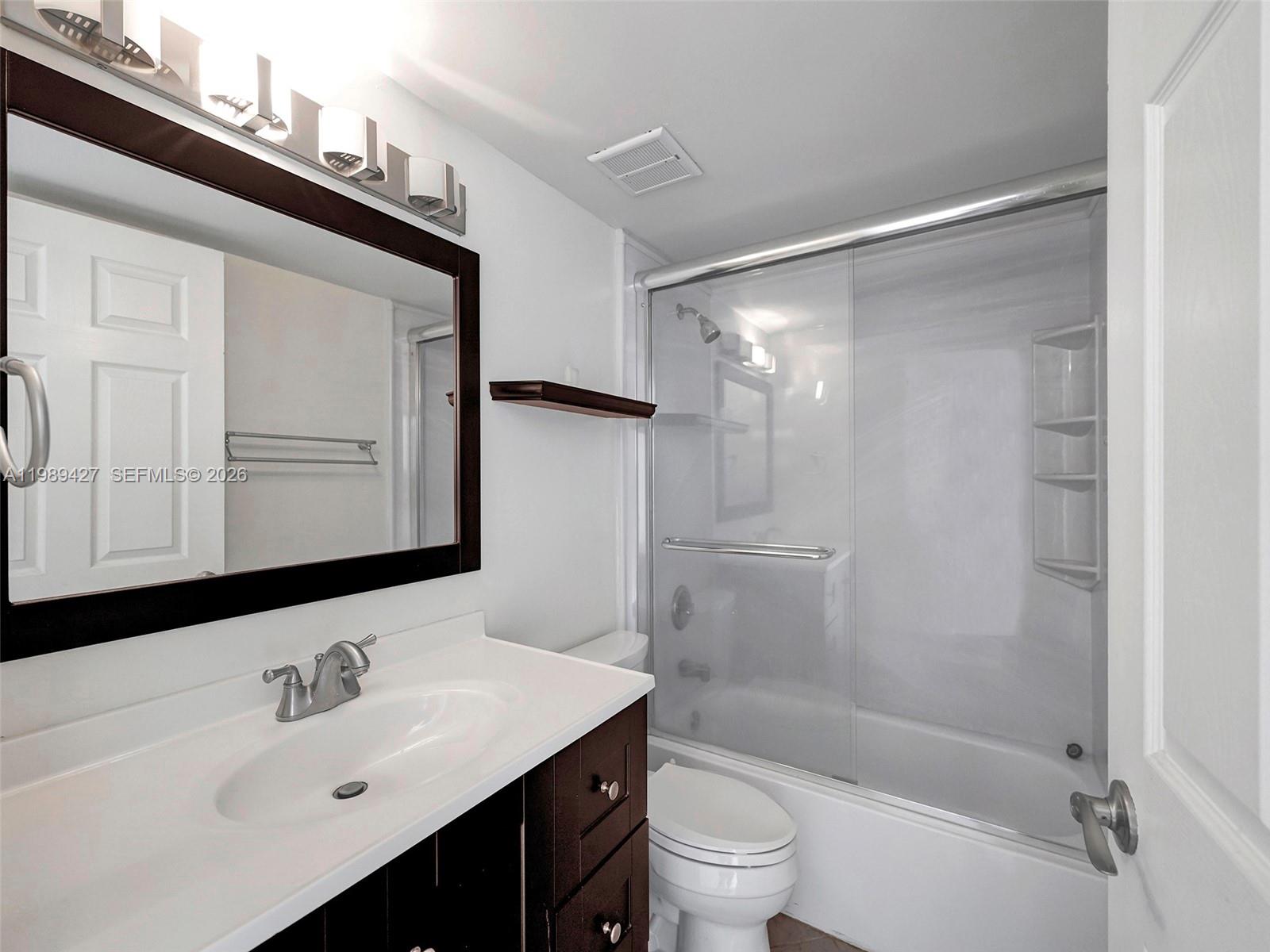 4600 Southwest 67th Avenue, Unit 155 Miami, FL 33155 - Photo 6 of 32 a bathroom with a bathtub shower sink vanity and toilet