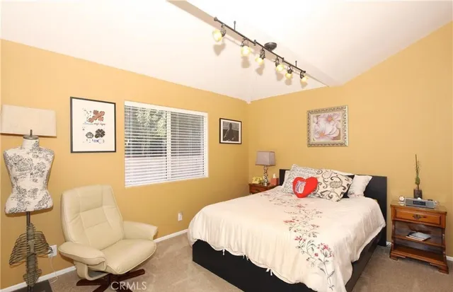 a spacious bedroom with a bed and a chair