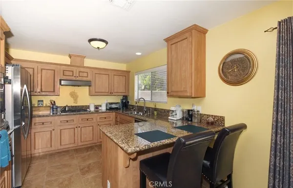 a kitchen with stainless steel appliances granite countertop a stove a sink and a refrigerator