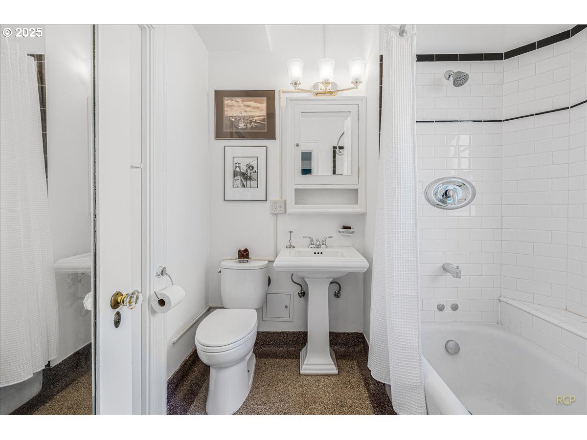2015 Northwest Flanders Street, Unit 408 Portland, OR 97209 - Photo 16 of 37 a bathroom with a sink a toilet a shower and a mirror