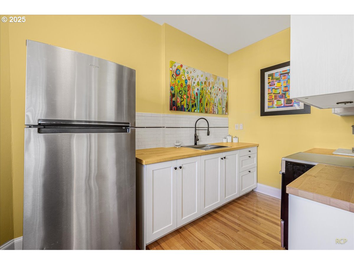 2015 Northwest Flanders Street, Unit 408 Portland, OR 97209 - Photo 6 of 37 a kitchen with stainless steel appliances a refrigerator and a sink