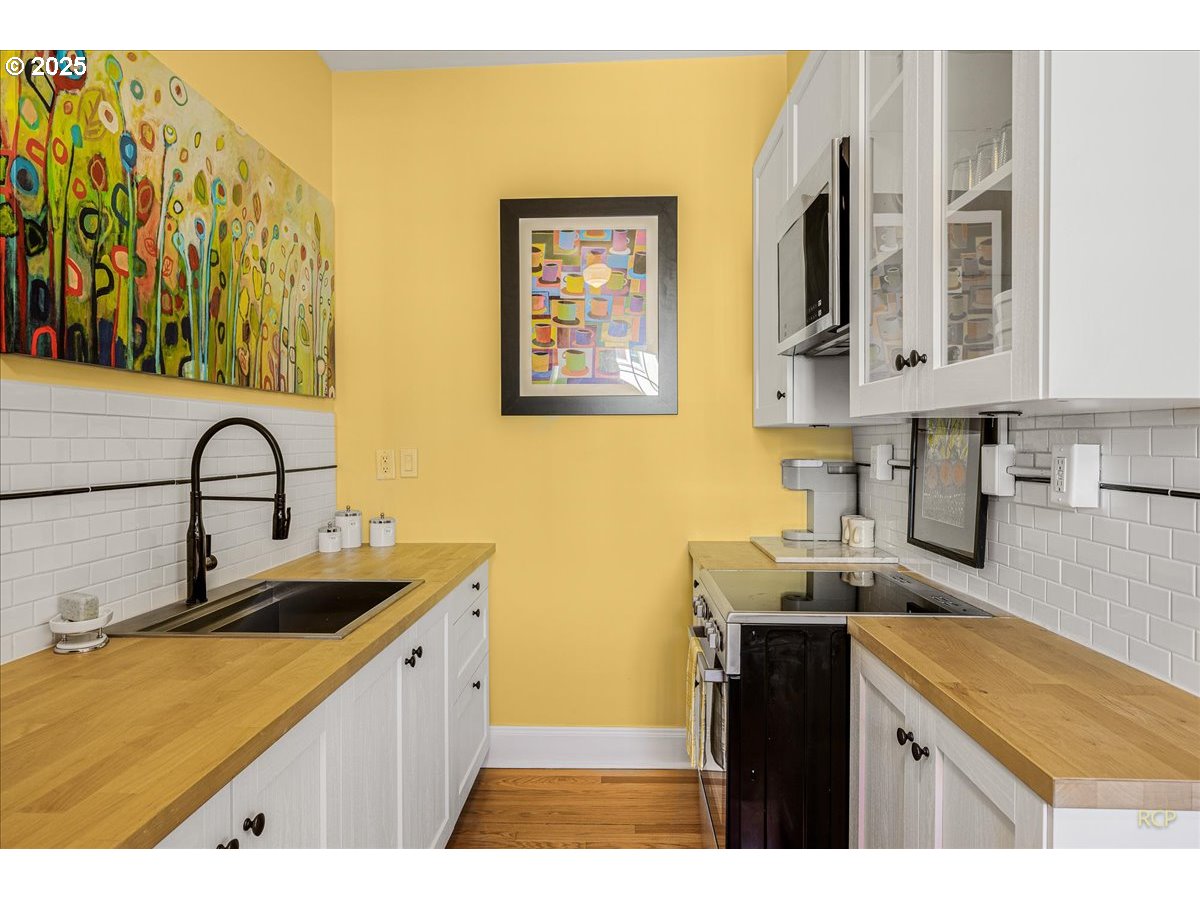2015 Northwest Flanders Street, Unit 408 Portland, OR 97209 - Photo 7 of 37 a kitchen with stainless steel appliances granite countertop a sink and cabinets
