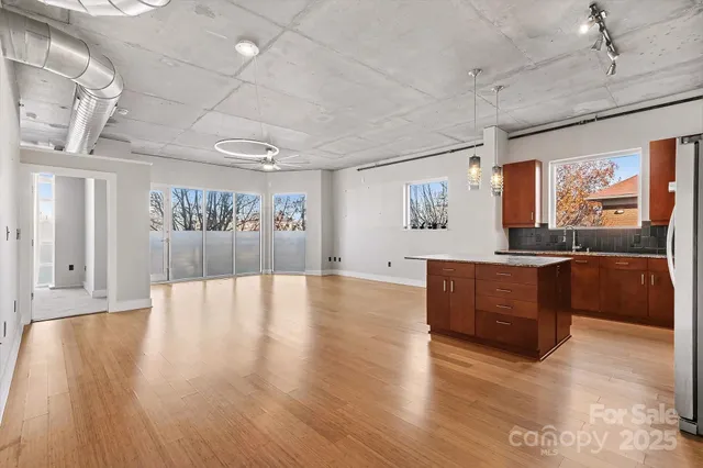 a large kitchen with stainless steel appliances granite countertop a large counter top and wooden floors