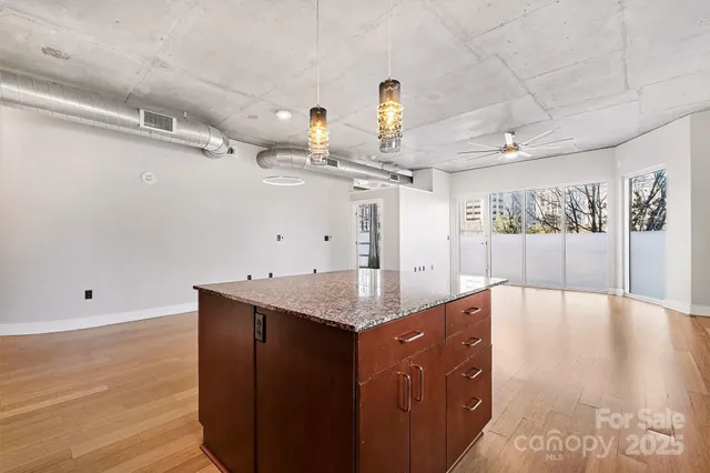 a view of an empty room with a chandelier fan