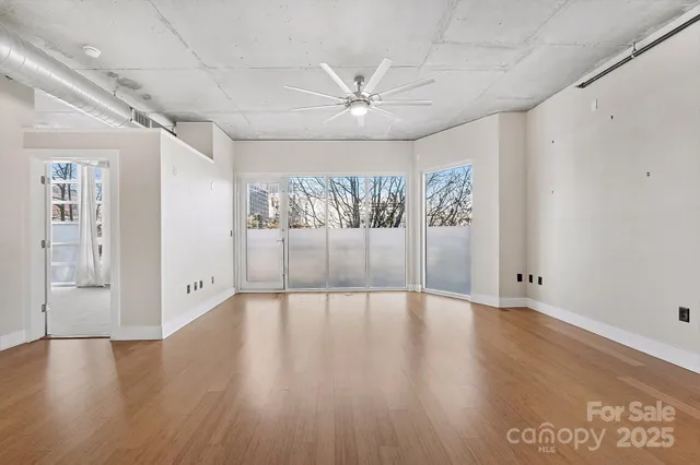 a large room with wooden floors and large windows