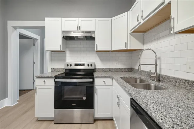 a kitchen with granite countertop a stove and a sink