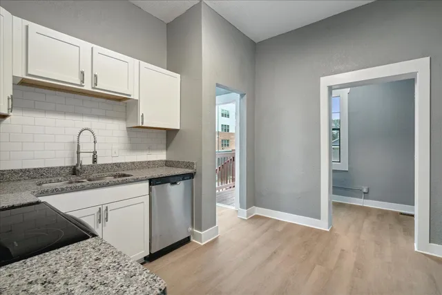 a kitchen with granite countertop a sink and cabinets