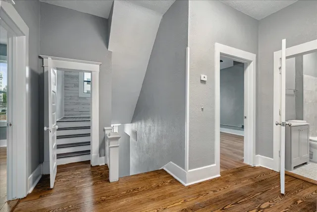 a view of a hallway with wooden floor and closet area