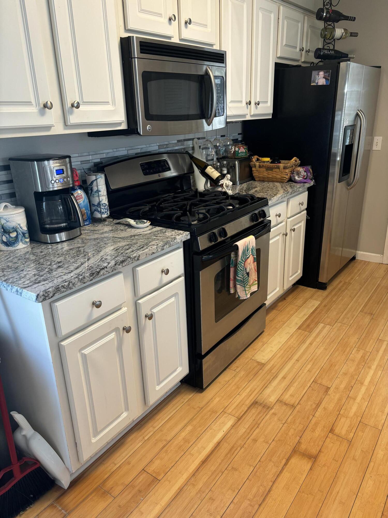 3863 Indian Trail, Unit 106 Destin, FL 32541 - Photo 14 of 22 a kitchen with stainless steel appliances granite countertop a stove a microwave and a refrigerator
