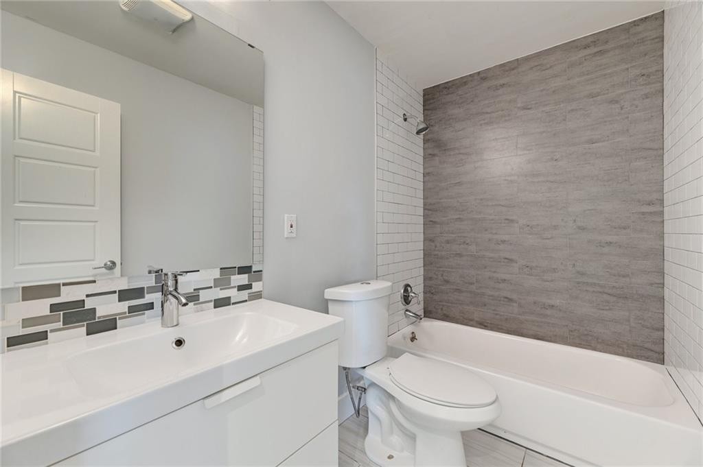 8318 Burrell Drive Austin, TX 78757 - Photo 17 of 27 Full bathroom with shower / bath combination, vanity, and decorative backsplash