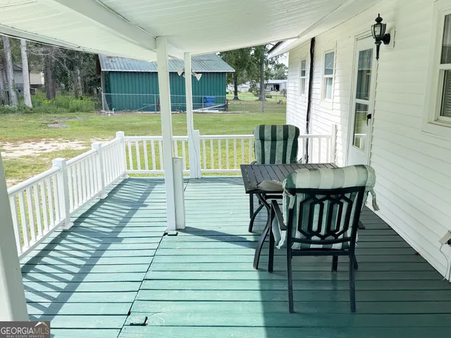 a view of a deck with table and chairs with wooden floor and fence