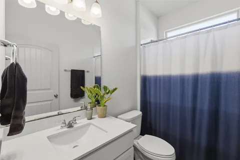 a bathroom with a sink vanity mirror and toilet